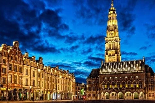 Lieux touristiques à visiter avec votre taxi à Arras Beffroi d’Arras illuminé à la tombée de la nuit.