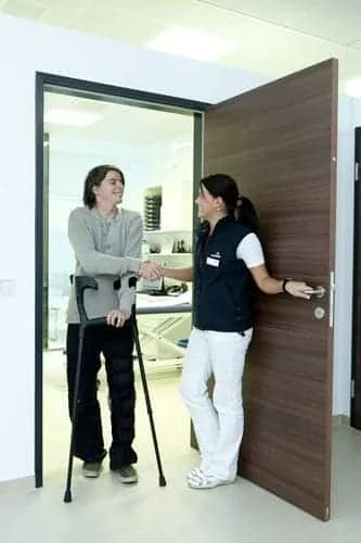 Transport et taxi conventionné médical avec votre taxi à Arras Professionnelle de santé accueillant une femme à la porte d’un cabinet.