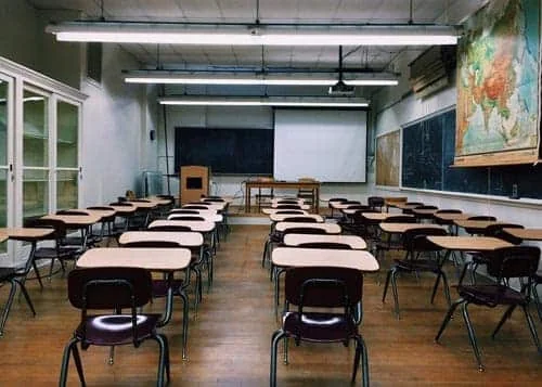 Transport scolaire en taxi avec 1 Taxi SVP à Arras et dans le Pas-de-Calais Salle de classe vide avec des tables et un écran de projection.